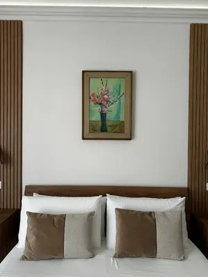 a bedroom with a bed with a picture on the wall at Terra d'amuri Rooms in Terrasini