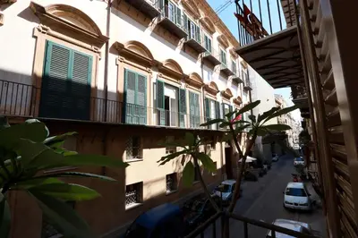 a building with green shutters and a car parked on a street at Oasi Porta Felice in Palermo