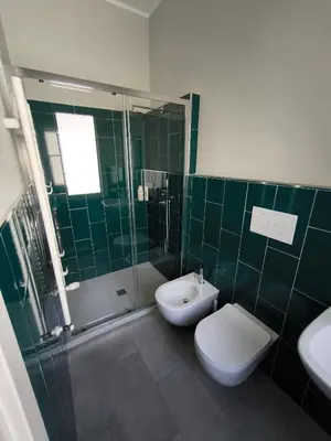 a bathroom with a toilet and a shower and a sink at Selenite Home in Palermo