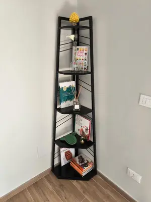 a shelf in the corner of a room with books at Selenite Home in Palermo