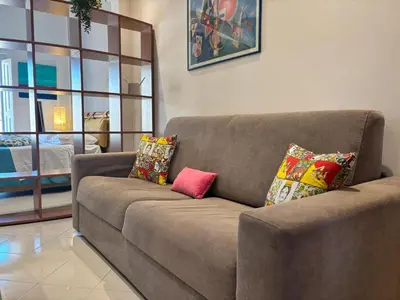 a brown couch with pillows on it in a living room at Teatro Massimo - Apartment with a View of Teatro Massimo in Palermo