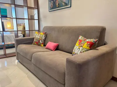 a brown couch with two pillows on it in a living room at Teatro Massimo - Apartment with a View of Teatro Massimo in Palermo