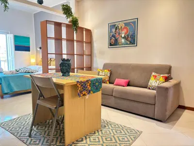 a living room with a couch and a table at Teatro Massimo - Apartment with a View of Teatro Massimo in Palermo