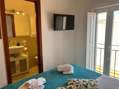 a bathroom with a bed and a sink and a mirror at Teatro Massimo - Apartment with a View of Teatro Massimo in Palermo