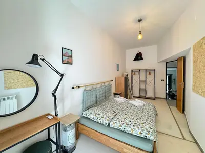 a bedroom with a bed and a mirror and a lamp at Backpackers House - Ballaró in Palermo