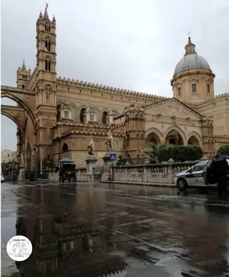 a large building with a clock tower on a street at Backpackers House - Ballaró in Palermo