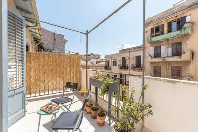 an apartment patio with chairs and plants on a balcony at Casa Beatrice con Terrazza by Wonderful Italy in Palermo