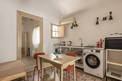 a kitchen with a table and a sink and a washing machine at Casa Beatrice con Terrazza by Wonderful Italy in Palermo
