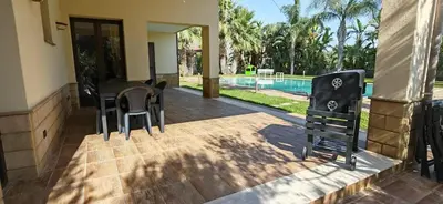 a patio with a table and chairs next to a pool at Villa Samay Luxury House in Carini