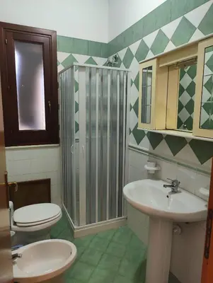 a bathroom with two toilets and a sink and a shower at Appartamento Gelsomino in San Vito lo Capo
