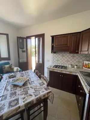 a kitchen with a table and a counter top at Appartamento Gelsomino in San Vito lo Capo