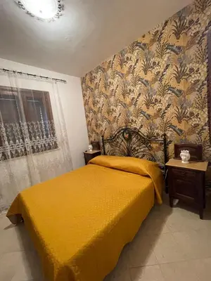 a bedroom with a bed with a yellow bedspread at Appartamento Gelsomino in San Vito lo Capo