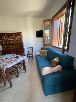 a living room with a blue couch and a table at Appartamento Gelsomino in San Vito lo Capo