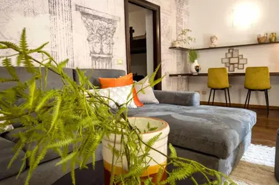 a living room with a gray couch and a plant at Central Panoramic View in Palermo