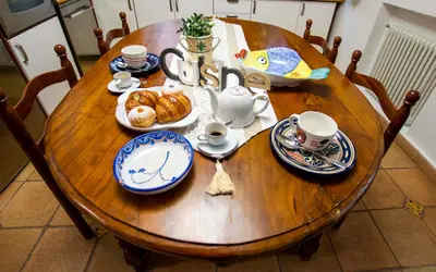 a wooden table with plates and cups and croissants on it at Central Panoramic View in Palermo