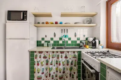 a kitchen with a sink and a stove top oven at More Holidays Beach in Mondello