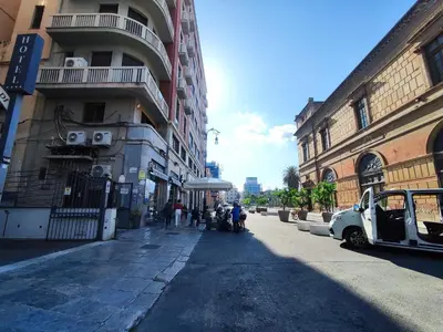 a city street with buildings and people walking down the street at Politeama guest house Palermo Agave in Palermo