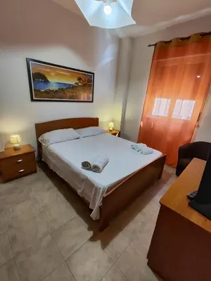 a bedroom with a large bed and a table and a desk at Politeama guest house Palermo Agave in Palermo