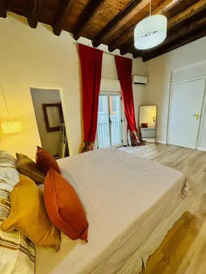 a large white bed in a room with red curtains at Centrale e accogliente Casa Papèl in Palermo