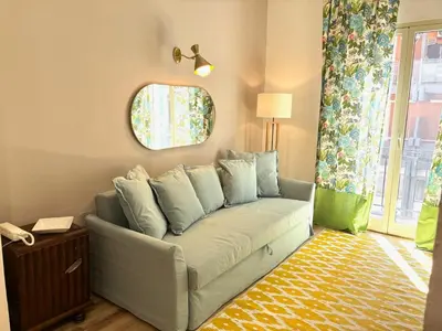 a living room with a couch and a mirror at Centrale e accogliente Casa Papèl in Palermo