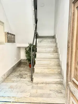 a stairwell with a stone tile floor and stairs with a plant at Centrale e accogliente Casa Papèl in Palermo