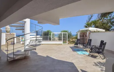 a patio with stairs and chairs on a house at 3 Bedroom Stunning Apartment In Alcamo in Alcamo
