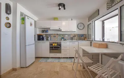 a kitchen with white cabinets and a table and chairs at 3 Bedroom Stunning Apartment In Alcamo in Alcamo