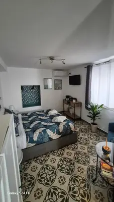 a bedroom with a bed and a table and a tv at Studio Bandiera in Palermo