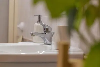 a bathroom sink with a faucet and a roll of paper towels at Casabra in Palermo