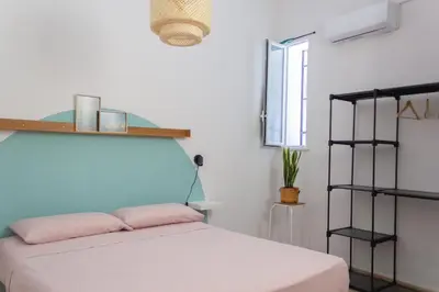 a bedroom with a white bed and a black shelf at Casabra in Palermo