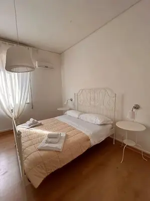a bedroom with a bed with a lamp and a table at Villa Marea Mondello in Palermo