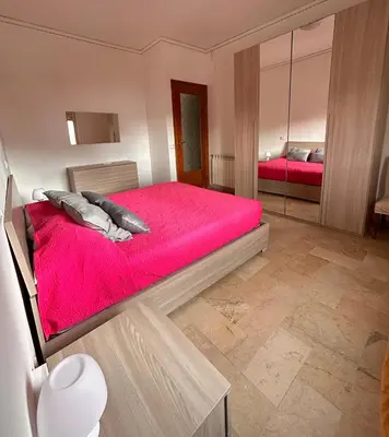 a bedroom with a red bed and a mirror at Villa Mia Mondello, 200m to beach, private parking in Palermo