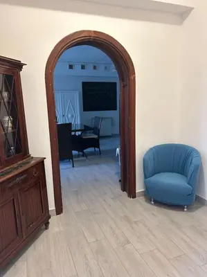 an archway in a living room with a blue chair at Villa Mia Mondello, 200m to beach, private parking in Palermo