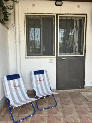 two chairs sitting outside of a house with a door at Villa Mia Mondello, 200m to beach, private parking in Palermo