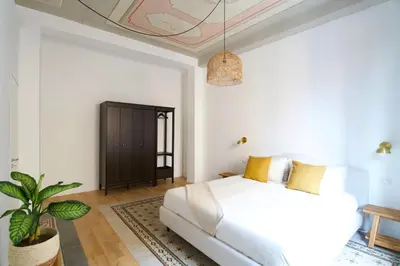a bedroom with a white bed and a potted plant at Casa Disìu in Palermo