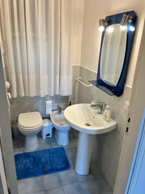 a bathroom with a sink and a toilet and a mirror at Villa del Limone , Mondello Via deucalione 18 ,via Miseno 18 in Palermo