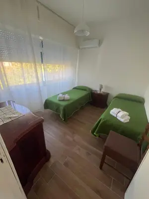 a bedroom with a bed and a large window at Villa del Limone , Mondello Via deucalione 18 ,via Miseno 18 in Palermo