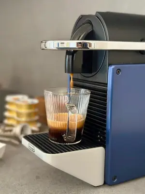 a coffee maker with a cup of coffee at Nika Palermo Holiday House in Palermo