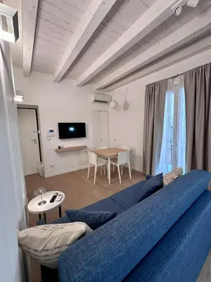 a living room with a blue couch and a table at Nika Palermo Holiday House in Palermo