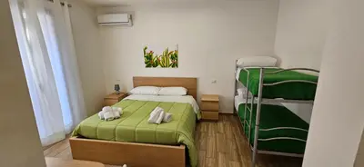 a small room with a bed and two bunk beds at Profumi di Sicilia in Cinisi