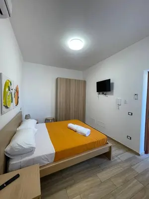a bedroom with a bed and a tv on the wall at Profumi di Sicilia in Cinisi