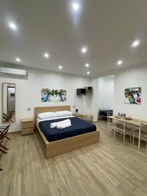 a bedroom with a bed and a table and a desk at Profumi di Sicilia in Cinisi