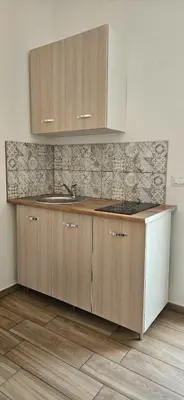 a kitchen with a sink and wooden cabinets at Profumi di Sicilia in Cinisi
