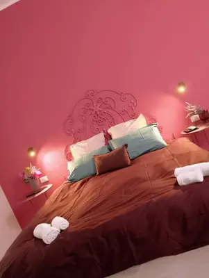 a bedroom with a large bed with pink walls at Le case di Caterina in Palermo