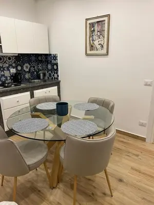 a dining room with a glass table and chairs at La Zisa Luxury Apartment in Palermo