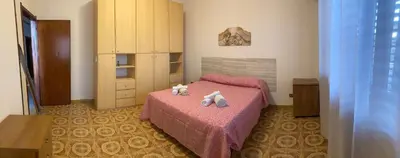 a bedroom with a pink bed with two stuffed animals on it at House of Lady in Carini