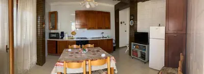 a kitchen with a table and a white refrigerator at House of Lady in Carini