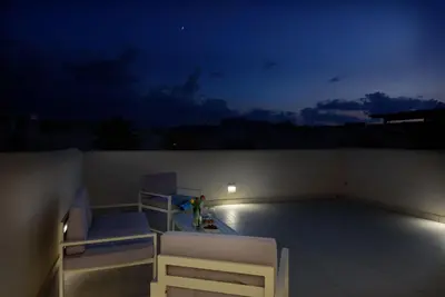 a balcony with two beds on a roof at night at Residence Mazzini in San Vito lo Capo