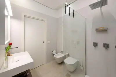 a white bathroom with a toilet and a glass shower at Residence Mazzini in San Vito lo Capo