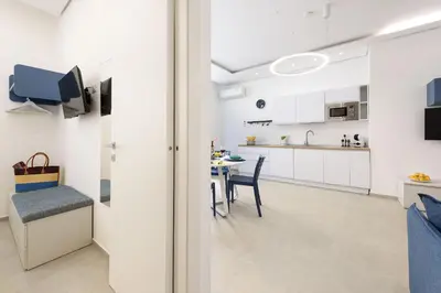 a kitchen and dining room with white cabinets and a table at Residence Mazzini in San Vito lo Capo